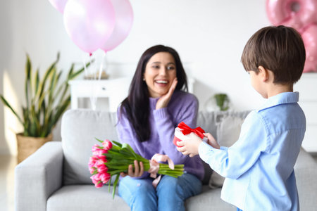 Little son greeting his mother for International Women's day at homeの写真素材