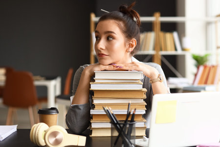 Beautiful female student with stack of books in library