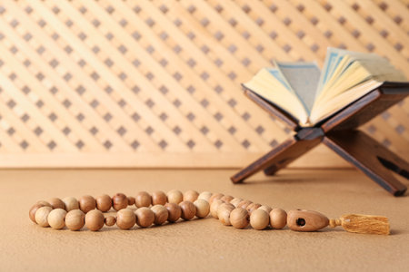 Rehal with Koran and Muslim prayer beads on tableの写真素材