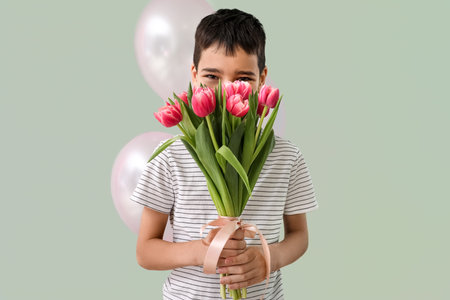 Little boy with tulips and balloons on green background. International Women's Dayの写真素材