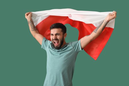 Happy young man with flag of Poland on green backgroundの写真素材