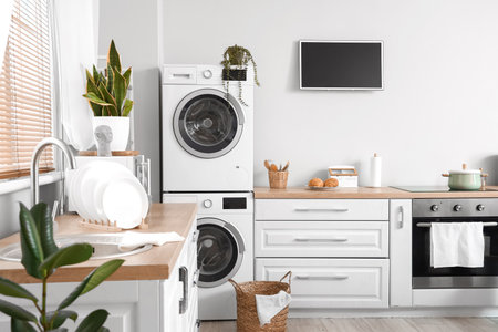 Stylish interior of kitchen with modern washing machinesの写真素材