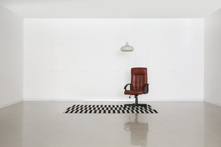 Office chair, carpet and hanging lamp near light wall