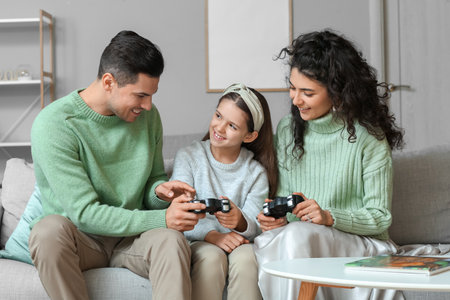 Happy family in warm sweaters with game pads at homeの写真素材