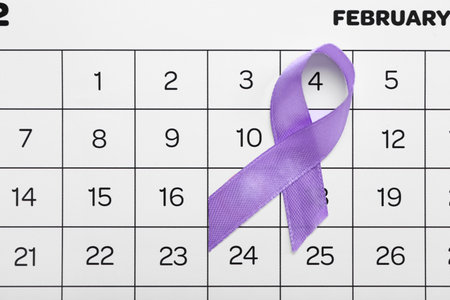 Awareness ribbon and paper calendar with marked date of World Cancer Day, closeupの写真素材