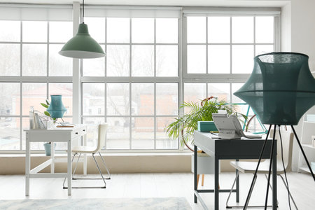 Interior of stylish office with comfortable workplaces and large windowsの写真素材