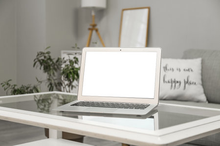 Modern laptop on glass table in roomの写真素材