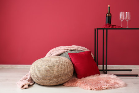 Poufs with plaid, pillow and pink carpet near red wallの写真素材