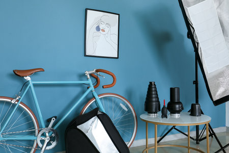 Bicycle and table with different equipment near color wall in photo studio interiorの写真素材