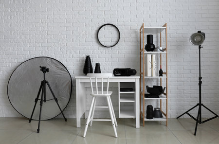 Workplace and shelf unit with different equipment in modern photo studio interiorの写真素材