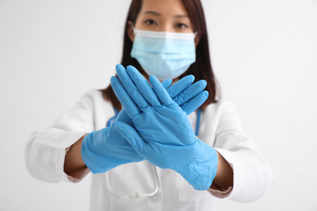 Female Asian doctor showing STOP gesture on white backgroundの写真素材