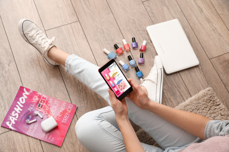 Female beauty blogger with smartphone sitting on floor, top viewの写真素材