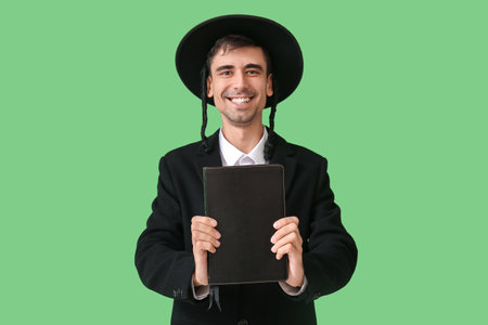 Hasidic Jewish man with Torah on color backgroundの写真素材