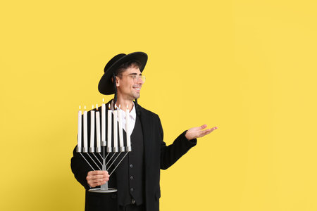 Jewish man with menorah showing something on color backgroundの写真素材