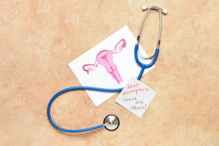 Papers with text DEAR MENOPAUSE LEAVE ME ALONE, uterus and stethoscope on beige backgroundの写真素材