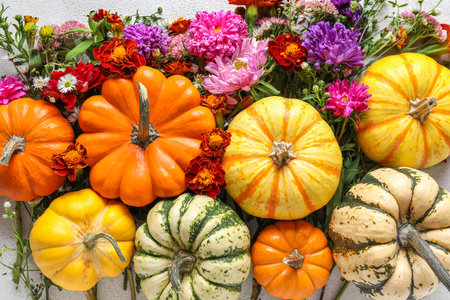 Composition with Halloween pumpkins and autumn flowers on table, closeupの写真素材