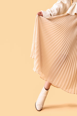 Beautiful fashionable young woman on beige backgroundの写真素材