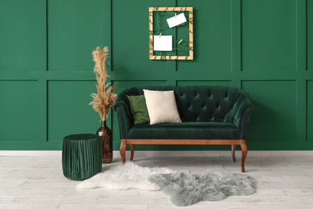 New sofa and pouf near green wallの写真素材