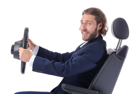 Young businessman in car seat and steering wheel on white backgroundの写真素材