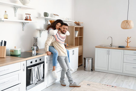 Happy young couple wearing warm sweaters at homeの写真素材