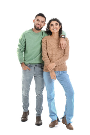 Happy young couple in warm sweaters on white backgroundの写真素材