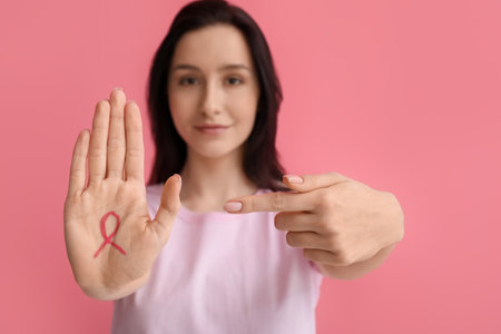 Young woman with ribbon on pink background. breast cancer awareness conceptの写真素材