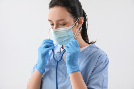 Portrait of female doctor with stethoscope on gray backgroundの写真素材