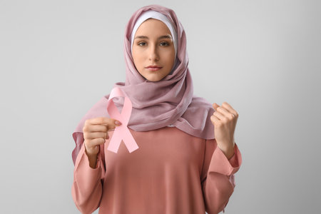 Muslim woman with pink ribbon on light background. breast cancer awareness conceptの写真素材