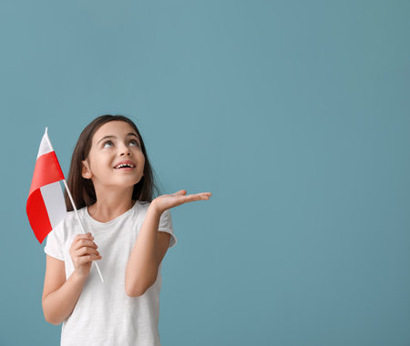 Cute little girl with flag of Poland on color backgroundの写真素材