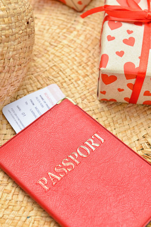 Passport with ticket on straw hat, closeup. Valentine's Day celebrationの写真素材