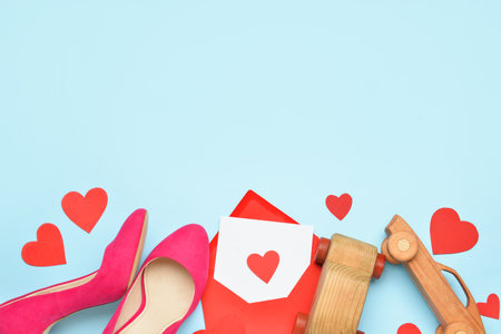Heels, envelope, wooden cars and paper hearts on blue background. Valentine's Day celebrationの写真素材
