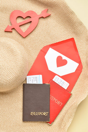 Passports with envelope, heart and hat on beige background. Valentine's Day celebrationの写真素材