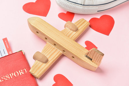 Wooden airplane with paper hearts on pink background, closeup. Valentine's Day celebrationの写真素材