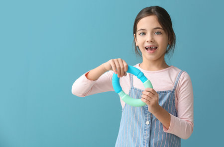 Little girl with Pop Tubes on blue backgroundの写真素材