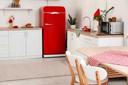 Dining table with napkin and chairs in light kitchenの写真素材