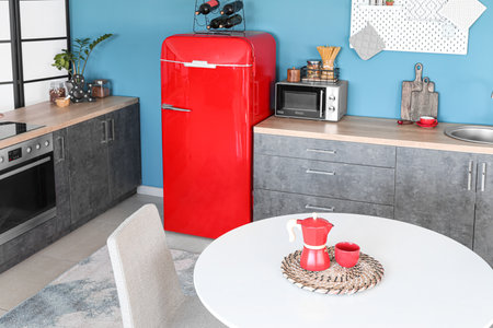 Interior of stylish kitchen with red fridge, counters and dining tableの写真素材