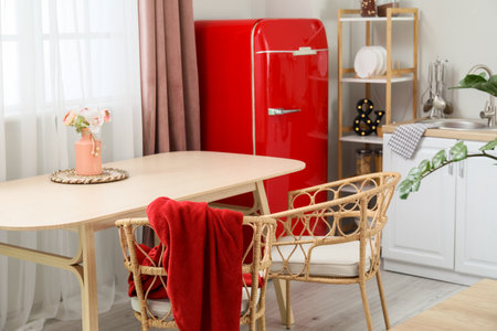 Vase with flowers on dining table in light kitchenの写真素材