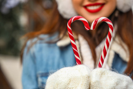 Woman holding candy canes on winter day, closeupの写真素材