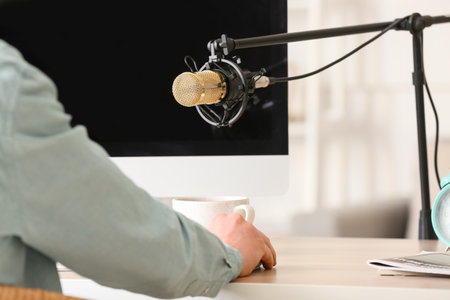 Man sitting near table with modern microphone at home, closeupの写真素材