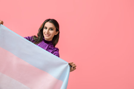 Beautiful young woman with unusual hair and transgender flag on color backgroundの写真素材