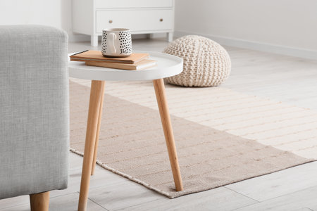 Table with cup and books in stylish living roomの写真素材