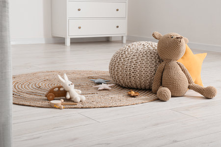Wicker carpet with pouf and toys in children's roomの写真素材