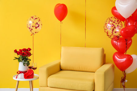 Armchair with beautiful balloons and gift with rose flowers for Valentine's Day in roomの写真素材