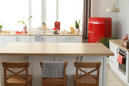 Stylish dining table, counters and new fridge in kitchenの写真素材