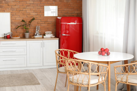 Interior of modern kitchen with stylish refrigerator, dining table and counterの写真素材