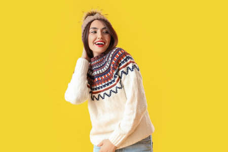 Pretty young woman in warm sweater on color background
