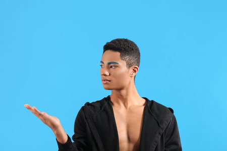 Fashionable young guy with unusual eyebrows on color backgroundの写真素材