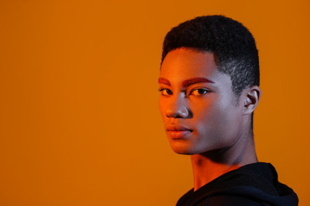 Fashionable young guy with unusual eyebrows on color backgroundの写真素材