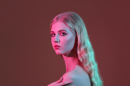 Beautiful girl with stylish makeup on color backgroundの写真素材