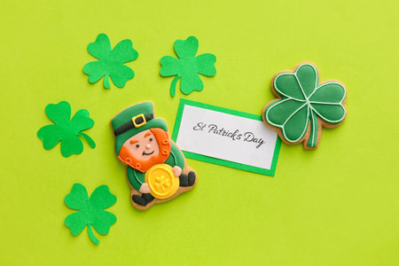 Composition with tasty gingerbread cookies for St. Patrick's Day celebration on green background